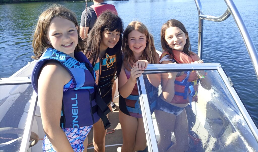 Girls in lifejackets on boat at BB Camp
