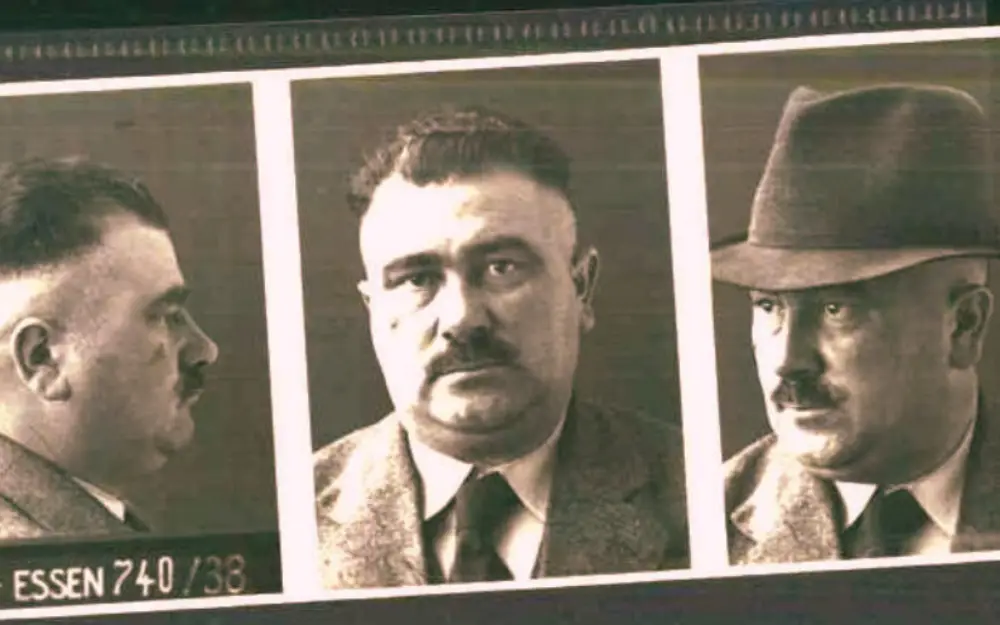 Mugshot strip of a mustached man in a suit shown in left profile, front, and right profile, with 'ESSEN 740/38' caption.