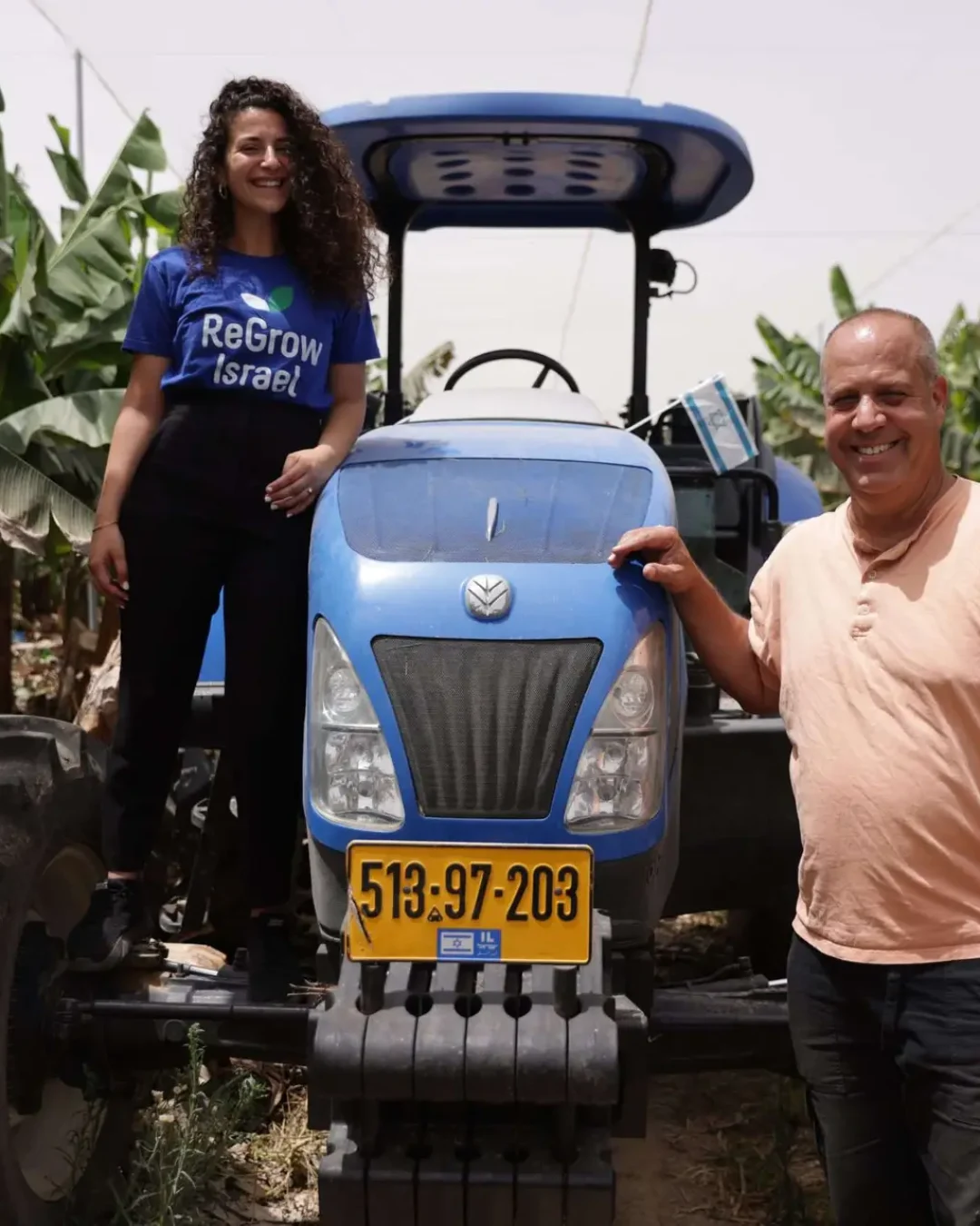 Man and Woman Smile with Tractor with Plants in BG
